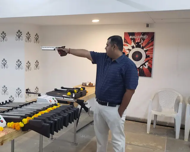 Chief coach demonstrating air pistol technique on the range