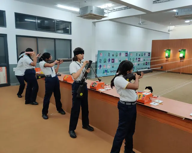 Young shooters learning stance and hold with a coach at a school range