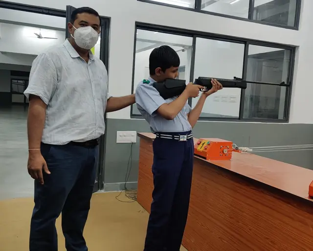 Coach correcting a young rifle shooter's position